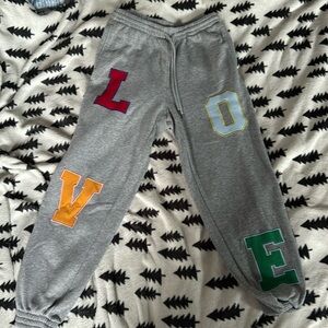 Gray sweatpants with cute embroidery spelling “love!”
